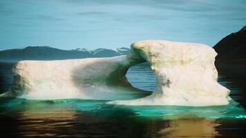 A large iceberg floating on top of a body of water video