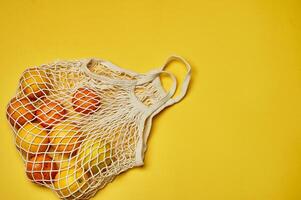 Replacing plastic bags. Taking care of the environment. Grid with fruit on colored paper, fortification. Minimalism. photo