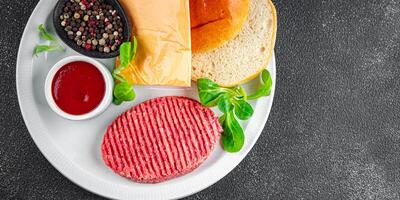 raw burger set cutlet, bun, cheese, tomato sauce, greens fresh cooking appetizer meal food snack on the table copy space food background rustic photo