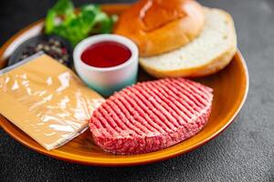 raw burger set cutlet, bun, cheese, tomato sauce, greens fresh cooking appetizer meal food snack on the table copy space food background rustic photo