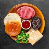 raw burger set cutlet, bun, cheese, tomato sauce, greens fresh cooking appetizer meal food snack on the table copy space food background rustic photo