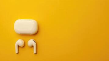 Chic wireless earbuds on a butter yellow background with ample copyspace for creative projects photo