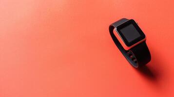 Soft coral background featuring a trendy fitness tracker with generous copyspace photo