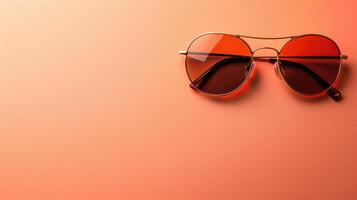 Peach background featuring a stylish pair of sunglasses with generous copyspace photo