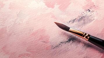 Artistic calligraphy brush on a dusty rose background with generous copyspace photo