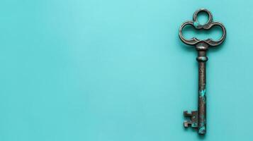 Antique key on a pastel teal background with ample copyspace, perfect for creative projects photo