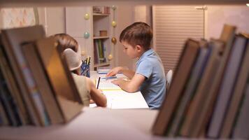 Children study at home. Boy Reading a Book at a Table in His Room video