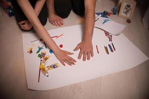 Two lovers draw with paints. Two lovers draw with paints. Hands are covered with paint . photo