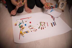 Two lovers draw with paints. Two lovers draw with paints. Hands are covered with paint . photo