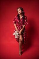 beautiful girl in a red dress on a red background with flowers photo