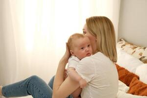 newborn baby in mom's arms. in the background the light from the window .the concept of mother's love for the child photo