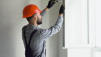 Worker installs and adjusts a new plastic window in house. Repairman regulates Installation and adjustment video