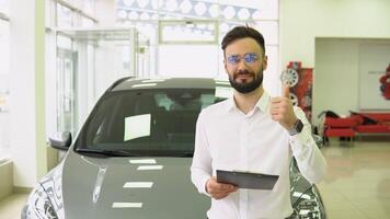 Portrait Of Handsome Car Salesman Posing At Workplace In Auto Showroom, Young Dealership Center Manager With Clipboard In Hands Helping To Purchase New Automobile, Free Space video