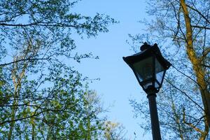 old street lamp on the background of clouds photo