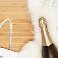 Bottle of champagne on a white fur rug with Christmas decoration photo
