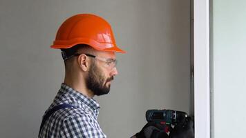 Man in uniform does pvc window installation with a screwdriver video