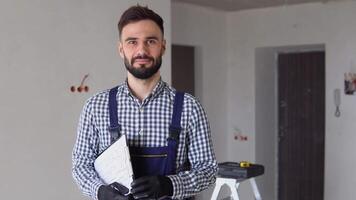 Young foreman builder, engineer or inspector with project documentation at construction site of apartment or office video