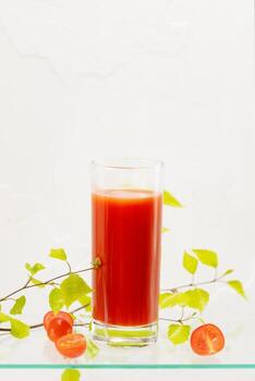 vaso de natural tomate jugo con Cereza Tomates en un vaso estante foto