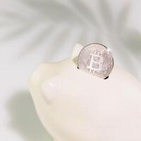 White Piggy bank with silver bitcoin coin on a blue background photo