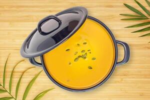 Pumpkin soup with seeds in a saucepan with a lid on a wooden table photo