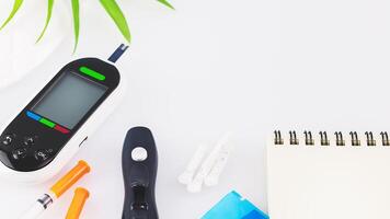 Diabetes control concept with glucose meter and notepad photo