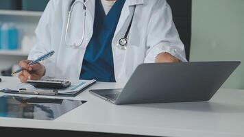 Doctor and nurse examining patient's medical records and medical team working on the background video
