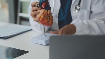 Doctor and nurse examining patient's medical records and medical team working on the background video