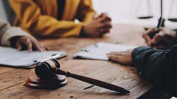 Lawyer shaking hands with a client making about documents, contracts, agreements, cooperation agreements with a female client at the lawyer's desk and a hammer at the table. video