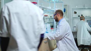 Multiethnic team of scientist working in medical laboratory, developing inovative drugs. Lab modernly equipped prepared for vaccine innovation using high tech, chemistry tools for scientific research, against virus development video