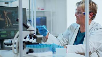 Medical lab worker analyzing blood serum conducting virus test in modern equipped lab. Multiethnic team examining vaccine evolution using high tech for treatment development against covid19 video