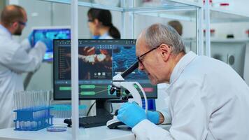 Medical research scientist conducting DNA experiments under microscope in modern equipped laboratory. Multiethnic team examining virus evolution using high tech for vaccine development against covid19 video
