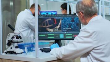 forskare i labb täcka arbetssätt på en dator i modern utrustad laboratorium. multietnisk team granskning vaccin Evolution använder sig av hög tech och kemi verktyg för vetenskaplig forskning, virus utveckling video