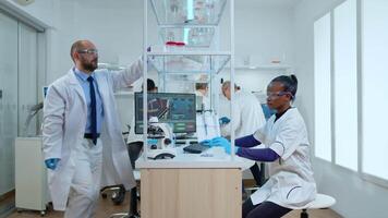 Group of diverse ethinc research scientists working on new generation disease cure. Multiethnic team examining vaccine evolution using high tech for research in treatment development against virus video