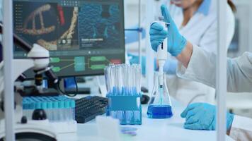 Close up of researcher testing liquid sample using micropipette for new treatment medical laboratory. Multiethnic team examining virus evolution using high tech for vaccine development against covid19 video