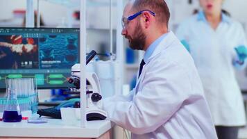 Diverse team of industrial scientists, engineers, developers innovating new vaccine in modern equipped laboratory. Team of doctors analysing virus evolution using high tech researching diagnosis video