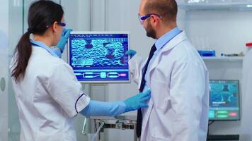 Chemists coworkers planning conducting vaccine against new virus in modern equipped laboratory. Multiethnic stuff analysing vaccine evolution using high tech for researching treatment against covid19 video