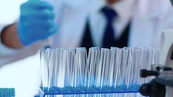 Close up of chemist filling test tube with liquid using pipette in equipped laboratory. Scientist analysing various bacteria, tissue and blood samples, pharmaceutical research for antibiotics video