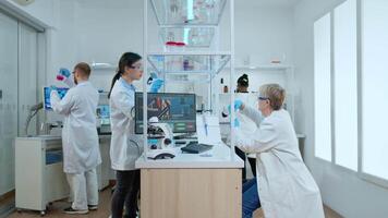 Timelapse of medical team working in modern equipped reasearch center. Multiethnic scientists examining vaccine evolution using high tech for research in treatment development against covid19 virus video