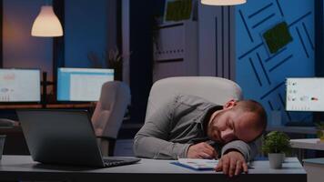 Exhausted overworked businessman sleeping on desk table in startup business office after analysing financial statistics late at night. Workaholic tired manager working at economic deadline project video