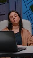 Tired overworkes businesswoman sleeping in startup company office on desk chair. Corporate collegue wake up and startworking at financial strategy planning economic meeting late at night video
