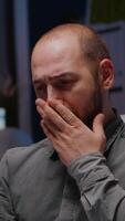 Sleepy businessman working overtime at management corporate deadline project. Workaholic entrepreneur sitting at desk table in startup office yawning while typing company strategy on laptop in evening video