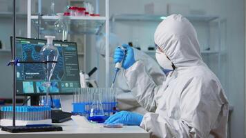 Chemist wearing ppe suit putting liquid in test tube with micropipette in laboratory. Team of doctors examining vaccine evolution using high tech and chemistry tools for virus development research video