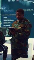 Vertical Female military officer supervising radar surveillance footage to input and process tactical data on a big screen. Woman uses global reconnaissance in creating battlefield maps. Camera B. video