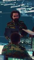 Vertical Crew captain and general briefing the troops in military headquarters command center, operating with a big screen to follow CCTV reconnaissance system. Soldiers collecting data. Camera B. video
