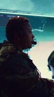 Vertical Female army operator registers important information from military surveillance system, working in control room base of operations to gather intelligence for the troops. National safety. Camera B. video