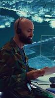 Vertical Military operator transmitting gps coordinates of hostile ships to national guard, providing real time data from surveillance CCTV system. Army officer works in power base control center. Camera B. video