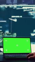 Vertical Army officer studies isolated greenscreen display on a laptop in control room, military power base personnel monitoring satellite world map for federal operations. Commander in uniform. Camera B. video