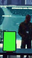 Vertical Isolated greenscreen display running on a tablet in military power base, soldiers follow surveillance footage to stay alert in case of a hostile attack. Satellite system for reconnaissance. Camera B. video