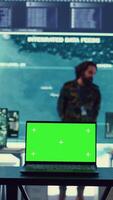 Vertical Laptop showing isolated mockup screen in army base of operations, military personnel working on gathering crucial information for a new mission. General headquarters with high tech. Camera B. video
