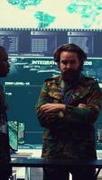 Vertical Diverse army officers examining real time data on a hologram, working with high tech holograph in a military command center for surveillance. Gather intelligence to support field troops. Camera B. video